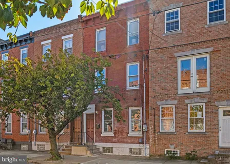 a front view of a building with a tree