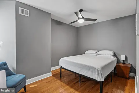 a bedroom with a bed and wooden floor