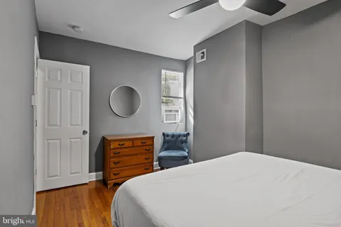 a hallway with a wooden floor and a chair