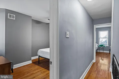 a bed sitting in a bedroom next to a window