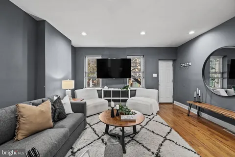 a living room with furniture a lamp and a flat screen tv