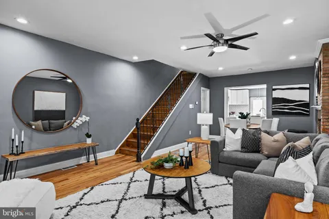 a living room with furniture and a wooden floor