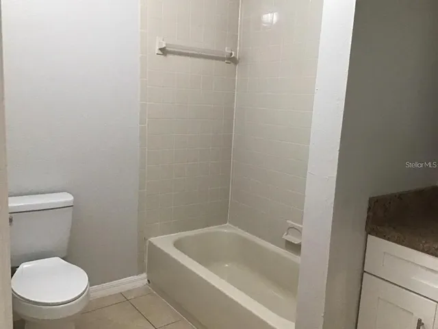 a white toilet sitting next to a bath tub