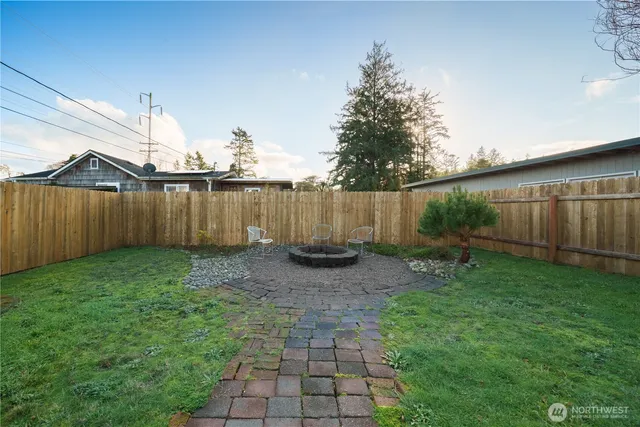 a view of a backyard with potted plants and a large tree