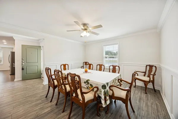 an empty room with wooden floor cabinet and windows