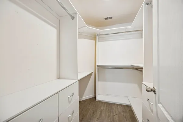 an empty room with wooden floor ceiling fan and windows