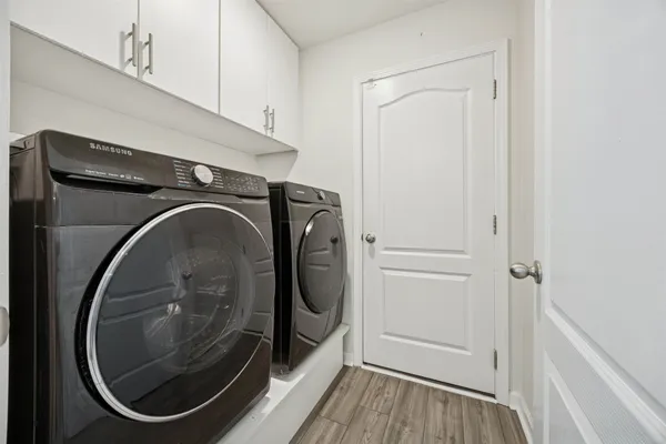a view of a house with a yard and large trees