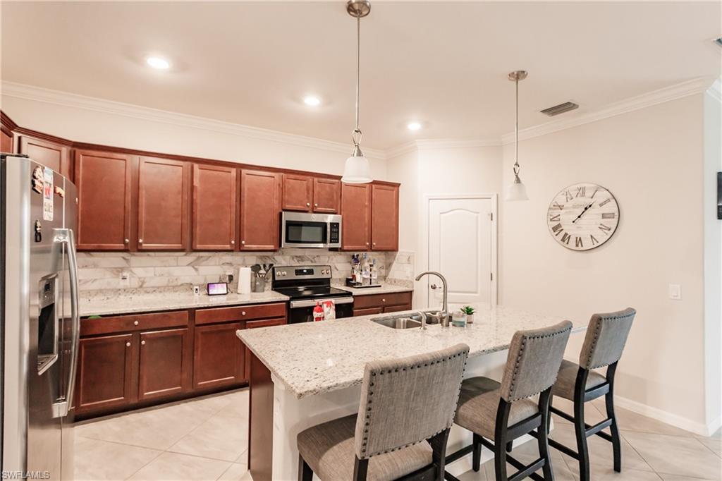 2247 Dancy Street Naples, FL 34120 - Photo 11 of 32 a kitchen with a sink a counter top space appliances and cabinets
