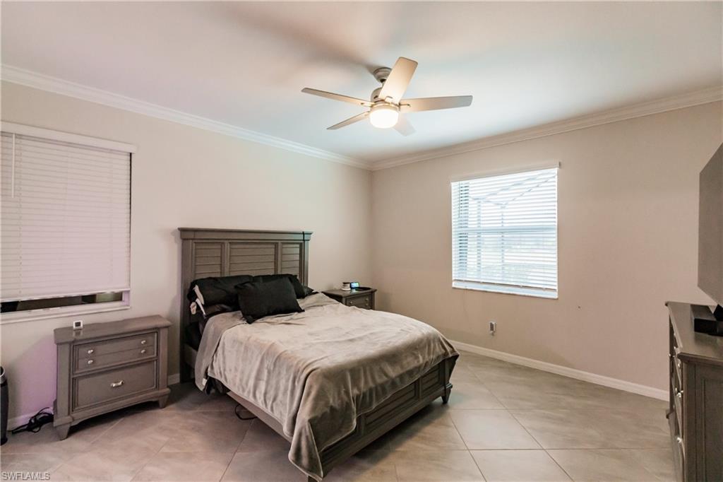 2247 Dancy Street Naples, FL 34120 - Photo 13 of 32 a bedroom with a bed and a chandelier