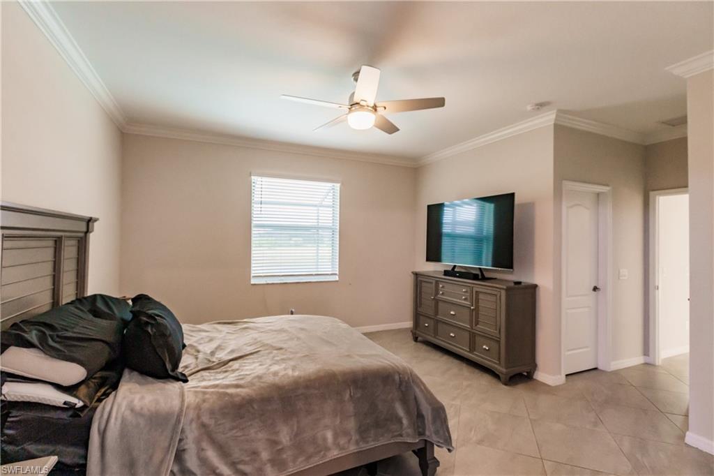 2247 Dancy Street Naples, FL 34120 - Photo 14 of 32 a bedroom with a bed and a flat tv screen on a dresser