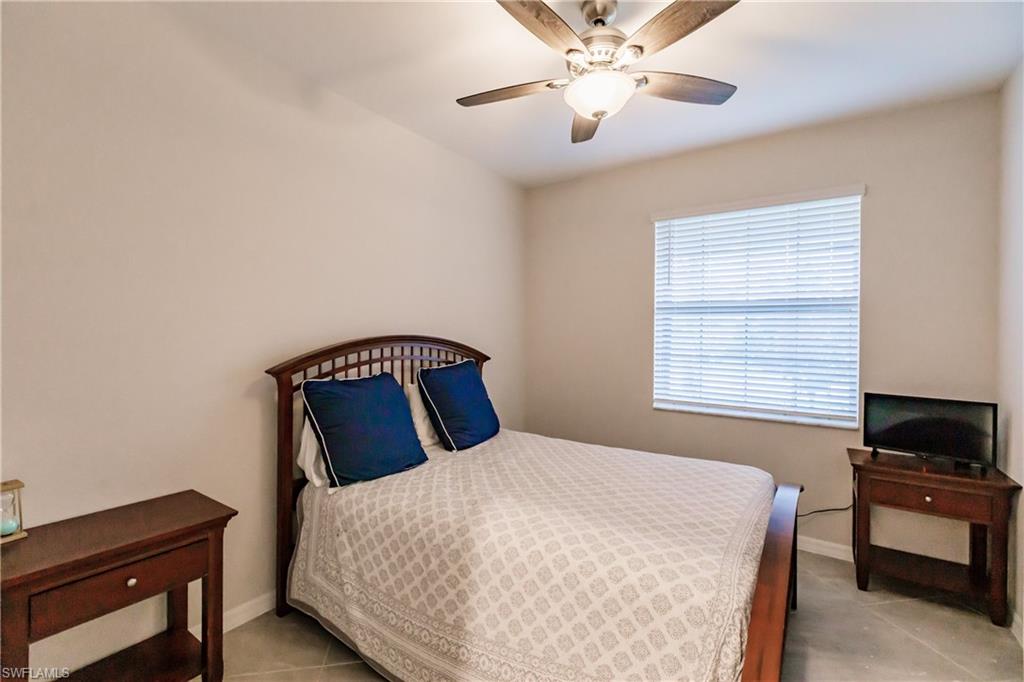 2247 Dancy Street Naples, FL 34120 - Photo 16 of 32 a bedroom with a large bed and a tv