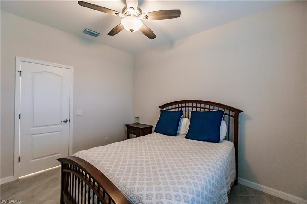 2247 Dancy Street Naples, FL 34120 - Photo 17 of 32 a bedroom with a bed and a ceiling fan