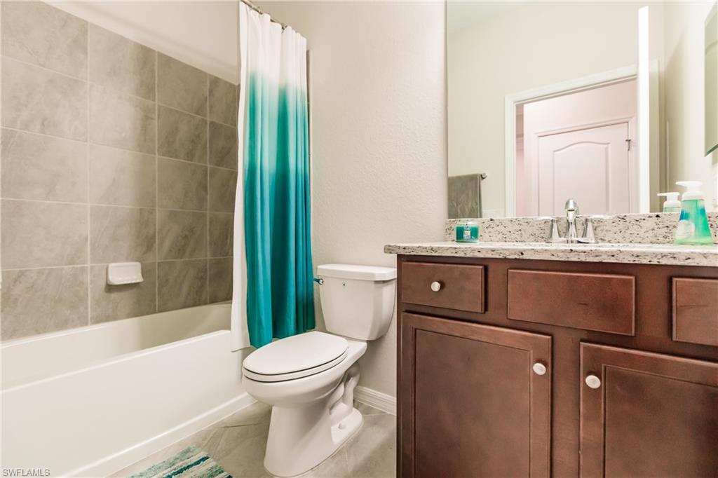 2247 Dancy Street Naples, FL 34120 - Photo 18 of 32 a bathroom with a granite countertop sink toilet and shower