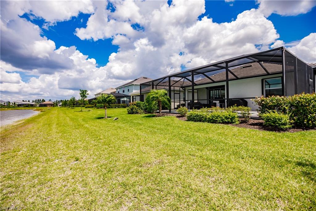 2247 Dancy Street Naples, FL 34120 - Photo 31 of 32 a view of a swimming pool with an outdoor seating and a yard