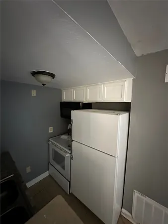 a white refrigerator freezer and a stove sitting inside of a kitchen
