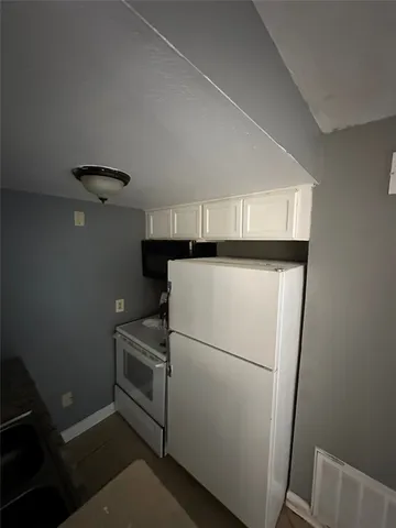 a white refrigerator freezer and a stove sitting inside of a kitchen