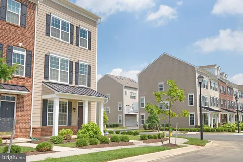 a front view of a multi story residential apartment building with yard and traffic signal