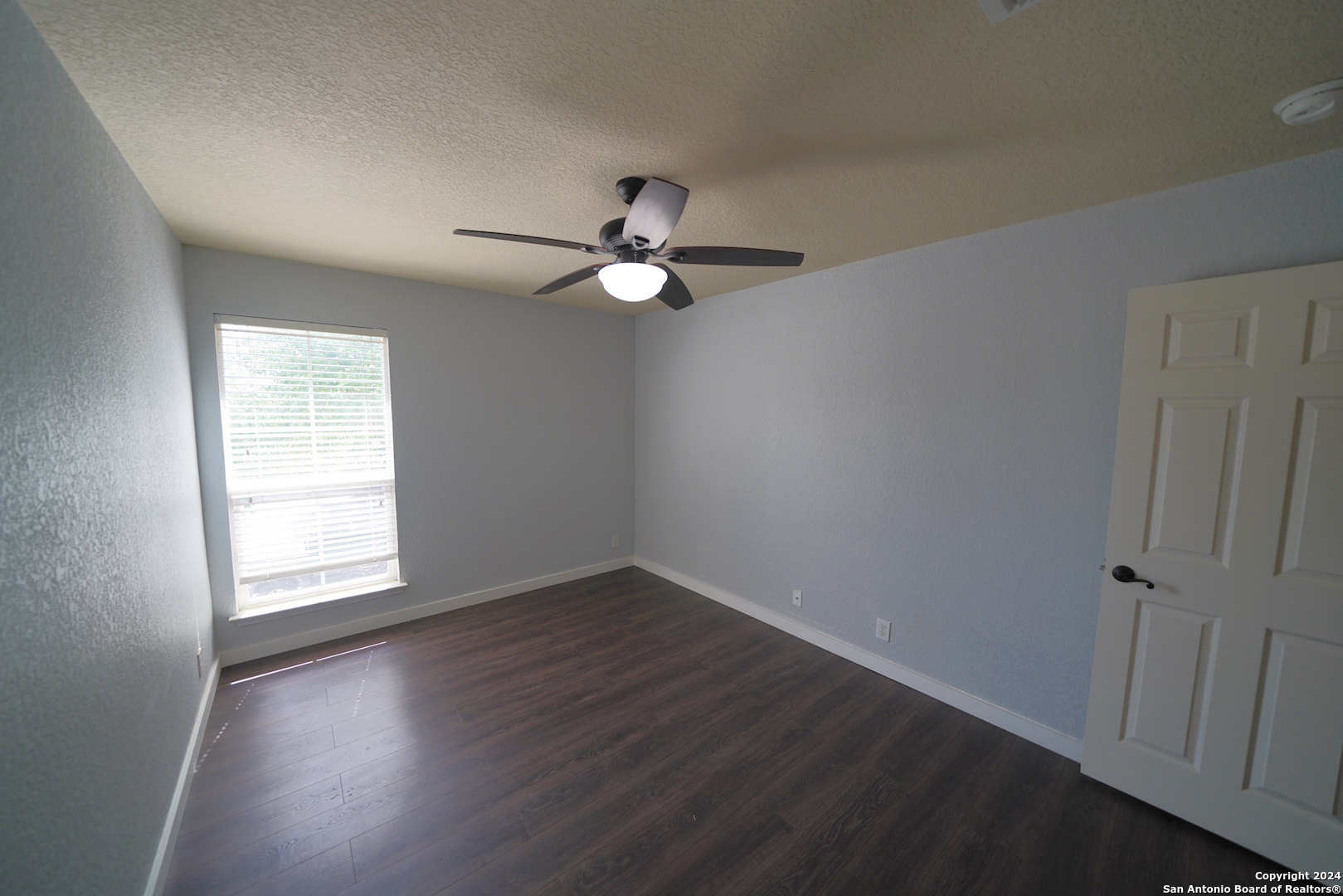 523 Diana Drive Converse, TX 78109 - Photo 34 of 50 an empty room with wooden floor fan and windows