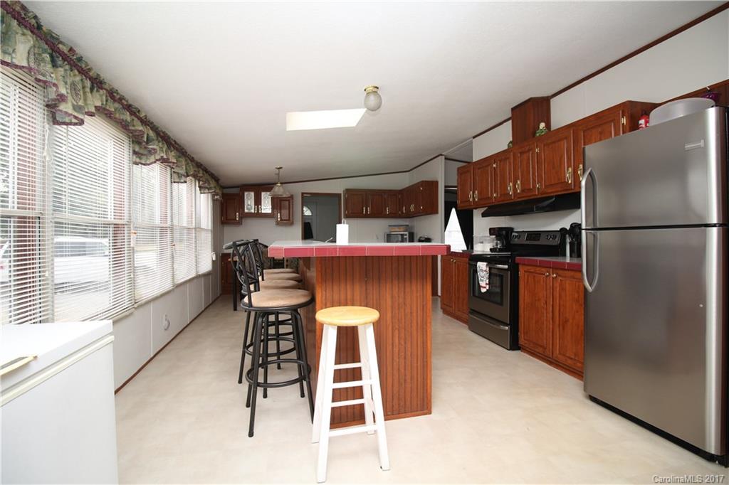 34927 Finger Road Mount Pleasant, NC 28124 - Photo 4 of 19 a kitchen with stainless steel appliances kitchen island granite countertop refrigerator stove dining table and chairs