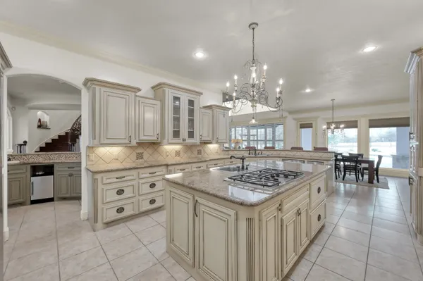 a kitchen with stainless steel appliances kitchen island granite countertop a stove a sink a table and chairs