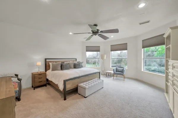 a bedroom with a bed and ceiling fan