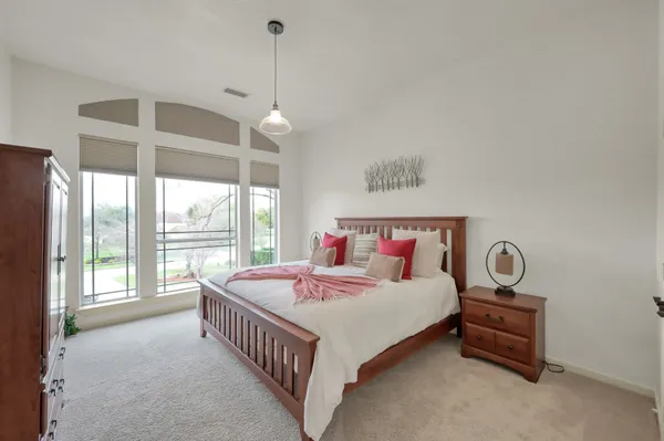 a spacious bedroom with a bed and a large window