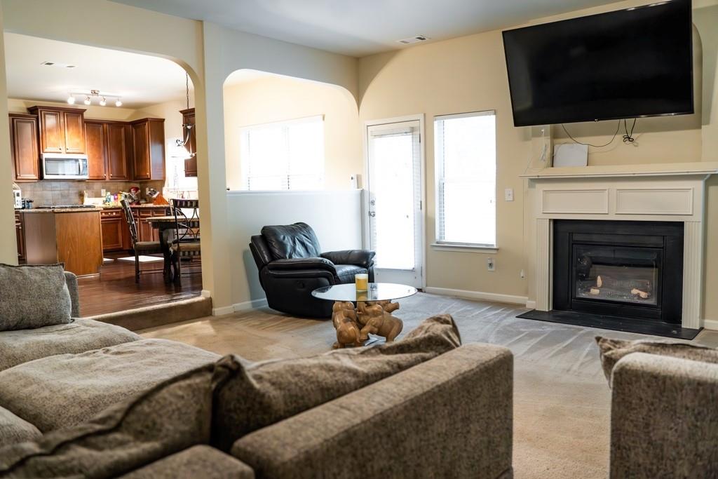 3830 Kittery Point Southwest Snellville, GA 30039 - Photo 12 of 35 a living room with furniture a fireplace and a flat screen tv