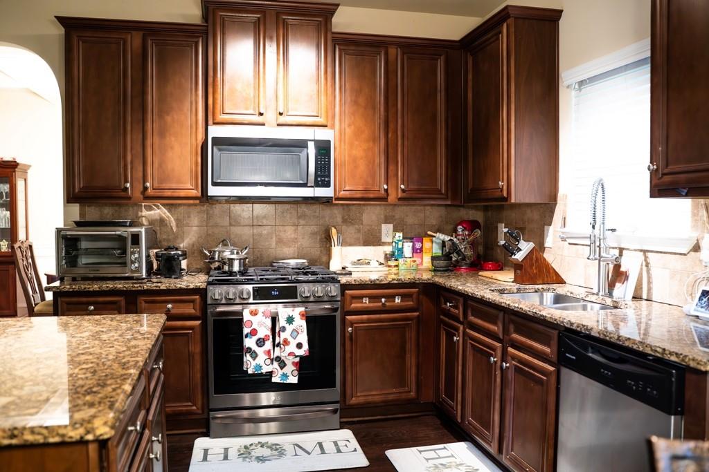 3830 Kittery Point Southwest Snellville, GA 30039 - Photo 6 of 35 a kitchen with stainless steel appliances granite countertop a stove a sink and a microwave