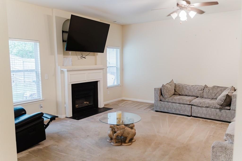 3830 Kittery Point Southwest Snellville, GA 30039 - Photo 10 of 35 a living room with furniture a flat screen tv and a fireplace