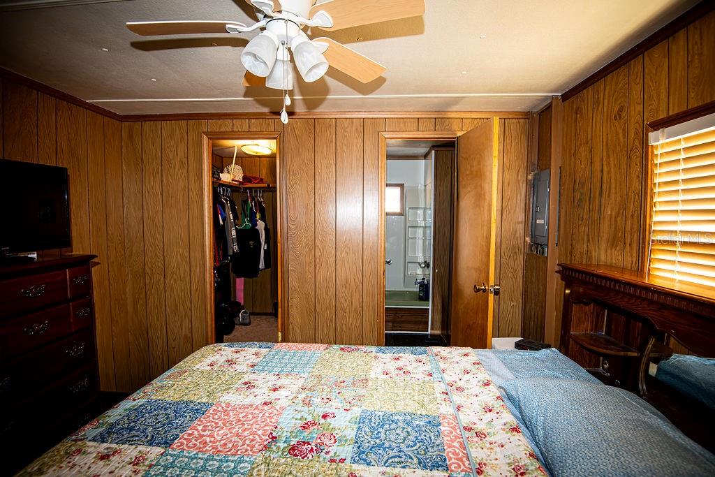 240 Kitty Avenue Interlachen, FL 32148 - Photo 19 of 44 a bedroom with a bed and a chandelier