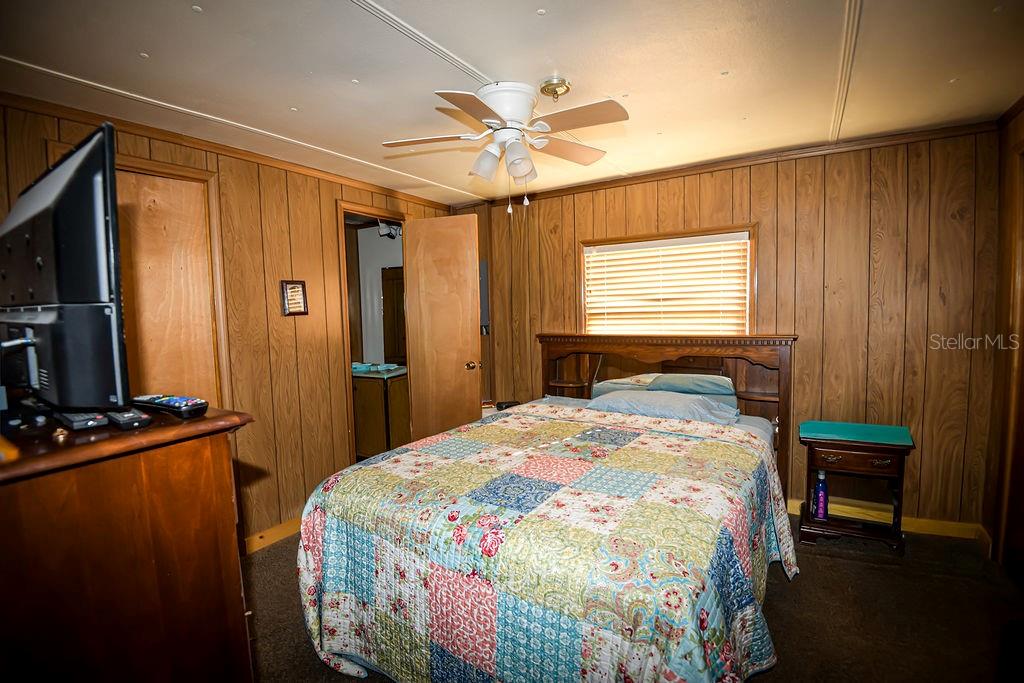 240 Kitty Avenue Interlachen, FL 32148 - Photo 20 of 44 a bedroom with a bed and a chandelier