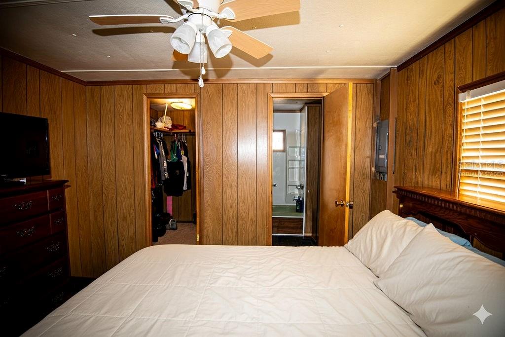 240 Kitty Avenue Interlachen, FL 32148 - Photo 21 of 44 a bedroom with a bed and a chandelier