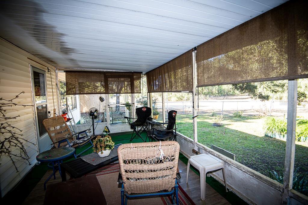240 Kitty Avenue Interlachen, FL 32148 - Photo 23 of 44 a view of a patio with table and chairs potted plants with floor to ceiling window