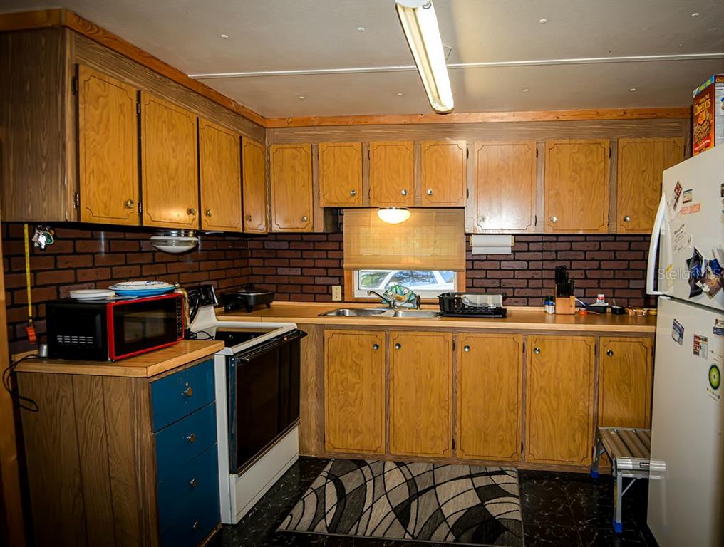 240 Kitty Avenue Interlachen, FL 32148 - Photo 10 of 44 a kitchen with stainless steel appliances granite countertop a stove a sink and a microwave