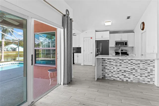 a view of a kitchen with a sink wooden floor and windows