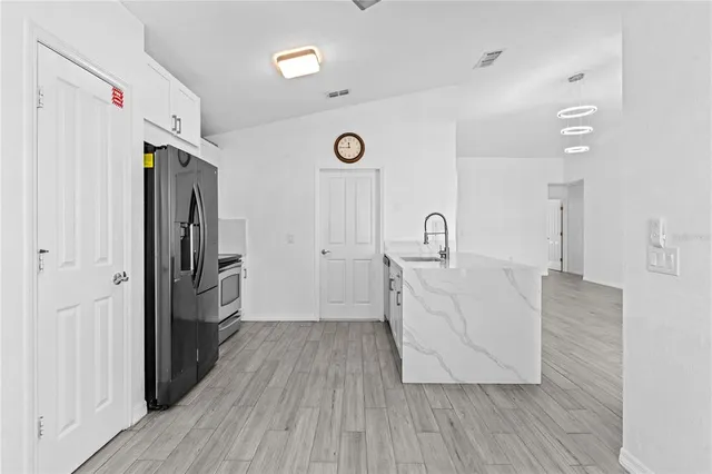 a view with granite countertop a sink cabinets wooden floor and a window