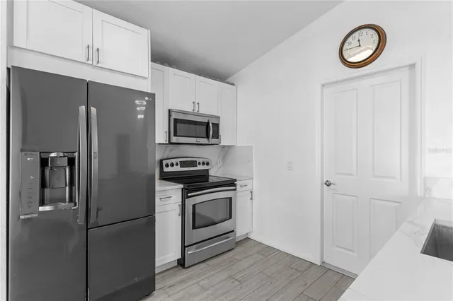 an empty room with wooden floor and a ceiling fan