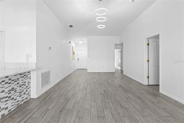 a view of an empty room with glass door and wooden floor