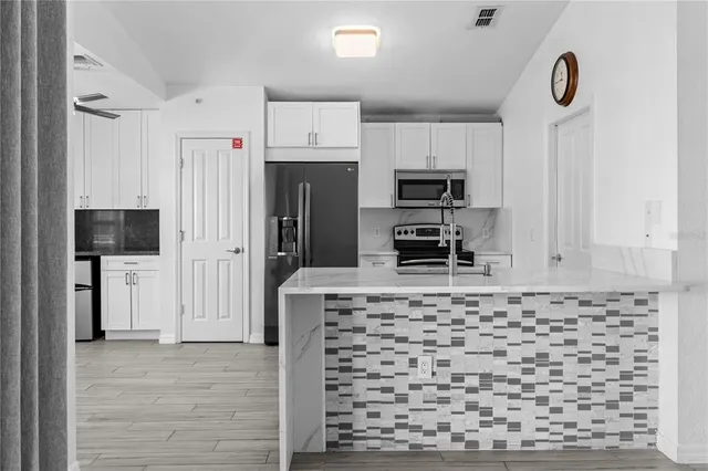 a kitchen with a refrigerator a sink and dishwasher with wooden floor