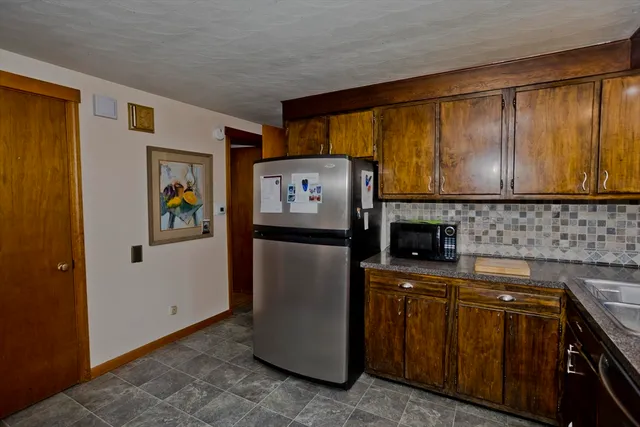 a kitchen with stainless steel appliances granite countertop a refrigerator and a stove top oven