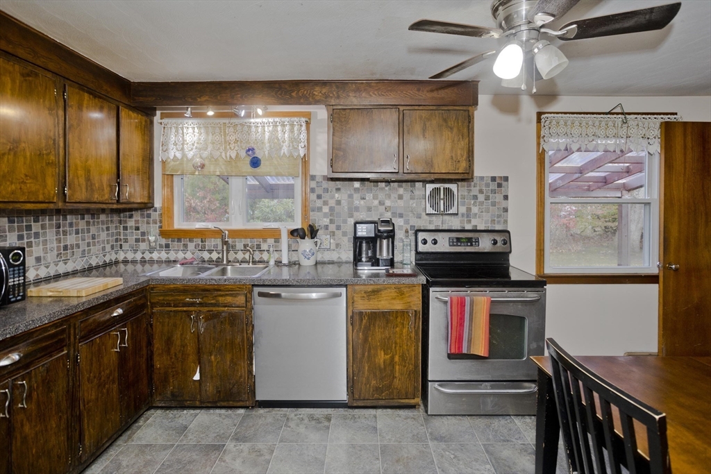 27 Regal Street Springfield, MA 01118 - Photo 4 of 32 a kitchen with stainless steel appliances granite countertop a sink and a stove