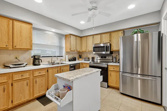 a kitchen with granite countertop stainless steel appliances a sink cabinets and a window