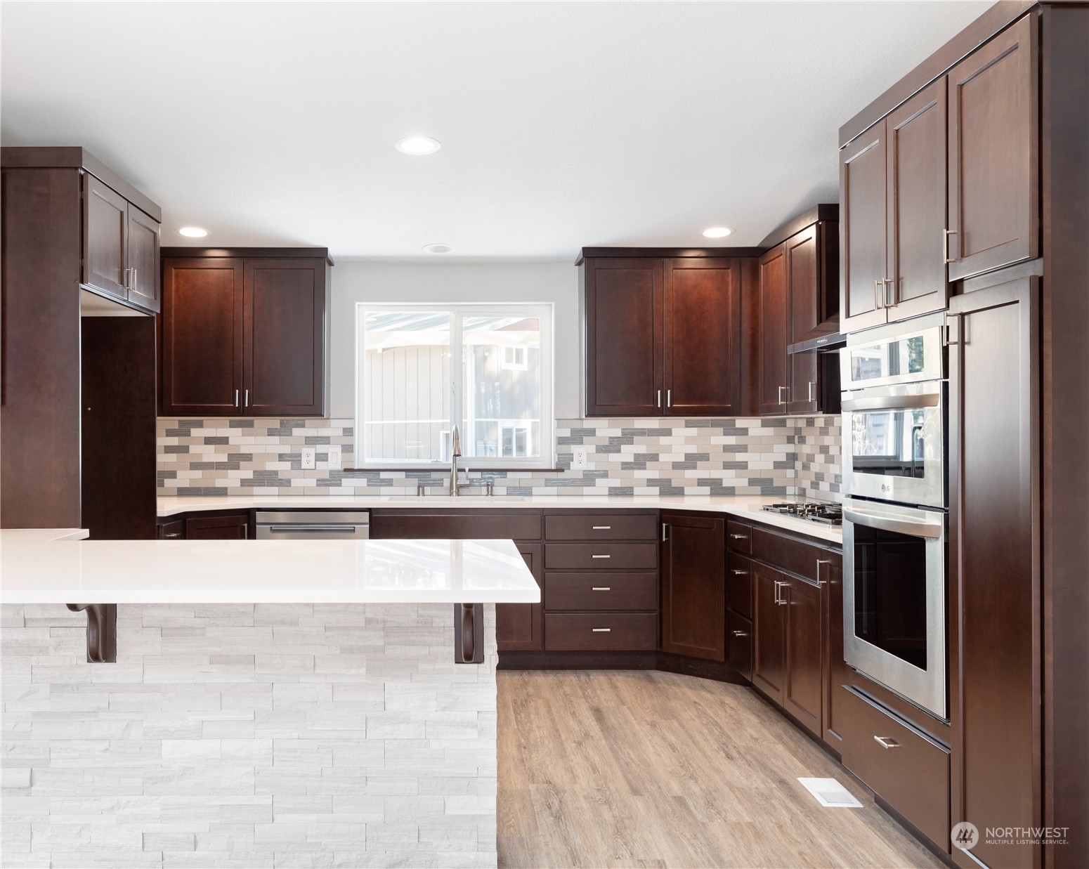 4656 Monkey Hill Road Oak Harbor, WA 98277 - Photo 34 of 40 a large kitchen with stainless steel appliances kitchen island granite countertop a stove refrigerator and cabinets