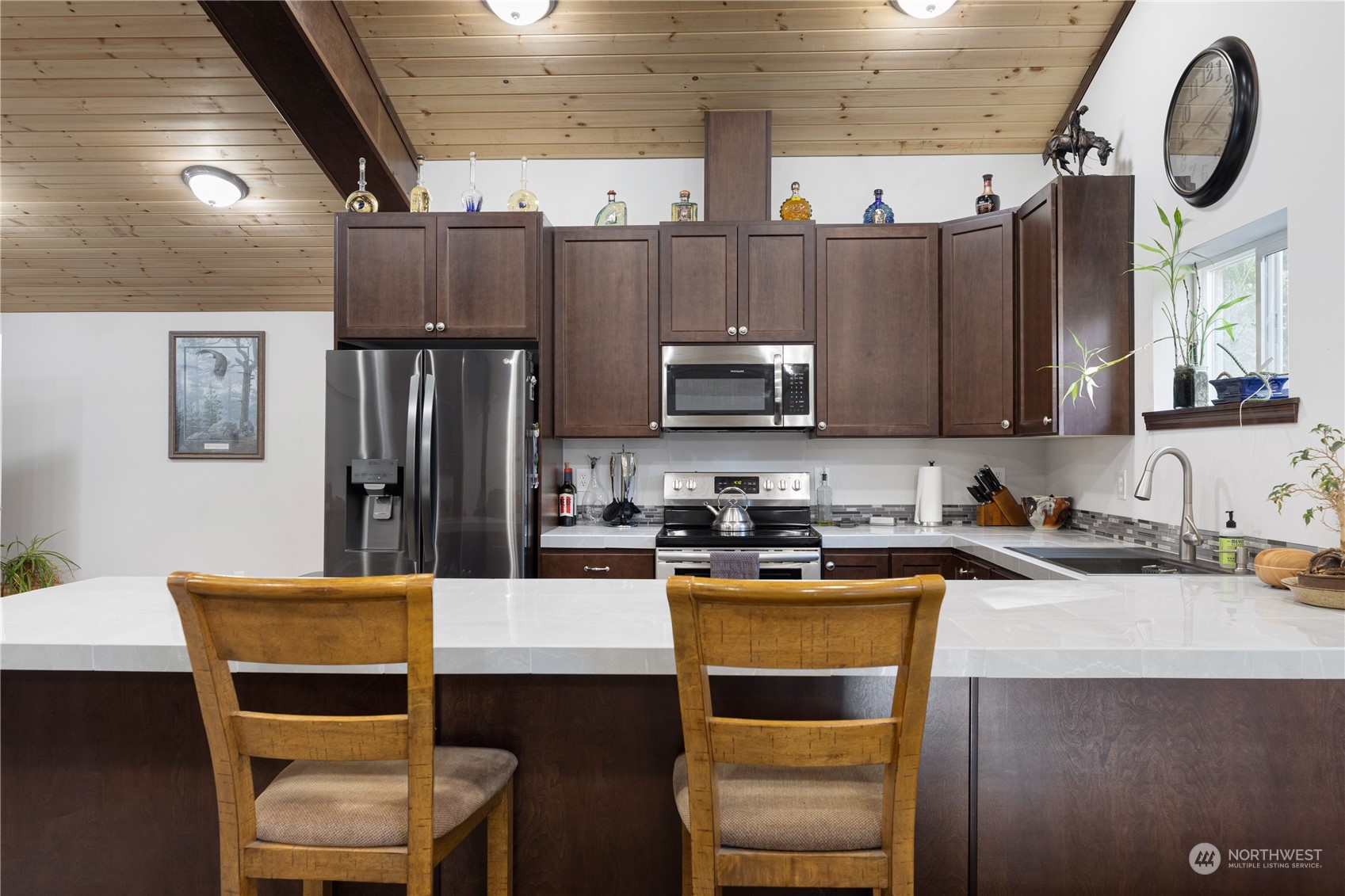 4656 Monkey Hill Road Oak Harbor, WA 98277 - Photo 39 of 40 a kitchen with a table chairs microwave and refrigerator