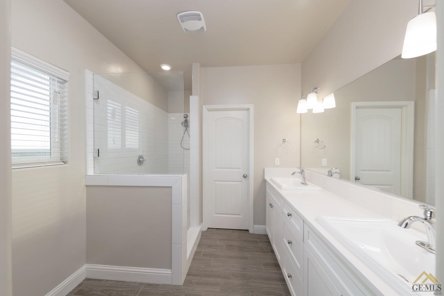 Undisclosed Address Shafter, CA 93263 - Photo 21 of 36 a spacious bathroom with a double vanity sink a mirror and a bathtub
