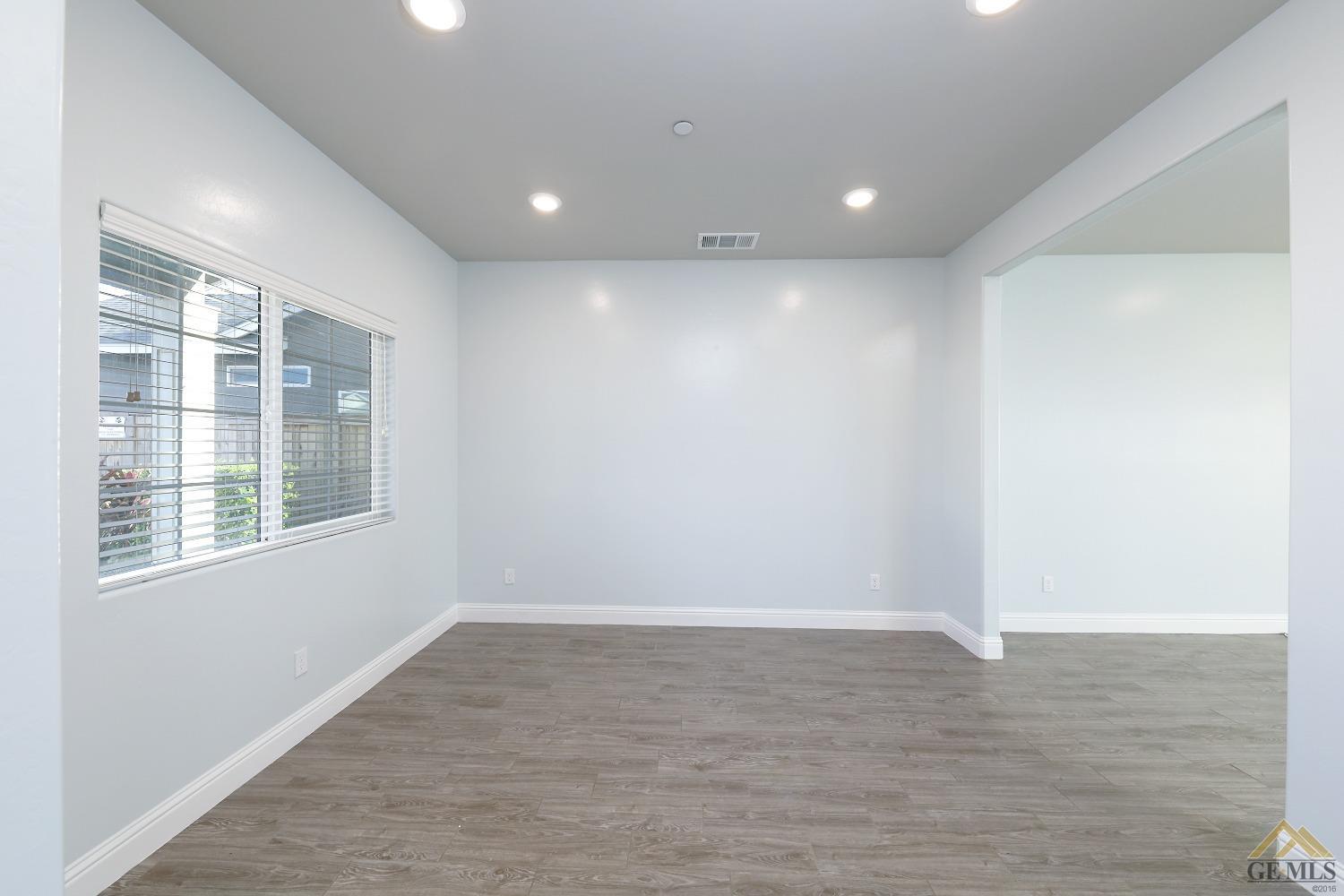 Undisclosed Address Shafter, CA 93263 - Photo 7 of 36 an empty room with wooden floor and windows