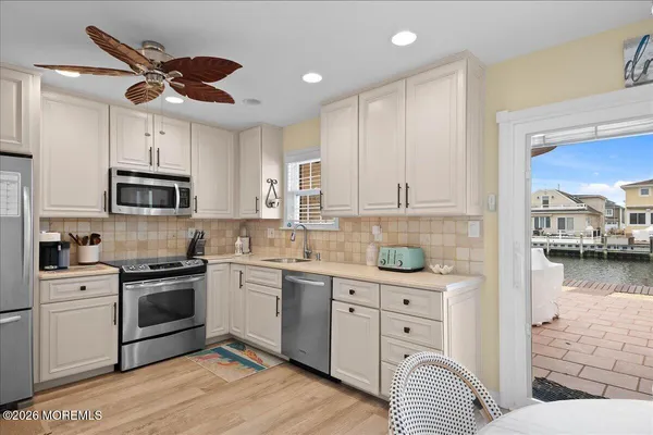 a kitchen with white cabinets and appliances