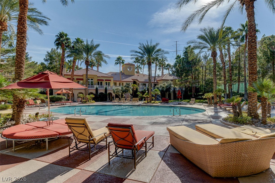 210 East Flamingo Road, Unit 208 Las Vegas, NV 89169 - Photo 36 of 42 Lush tropical landscaping surrounds this resort-style swimming pool, offering a serene outdoor oasis.