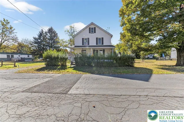 a front view of a house with a yard and trees