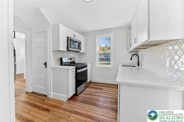a kitchen with granite countertop a sink and a stove top oven